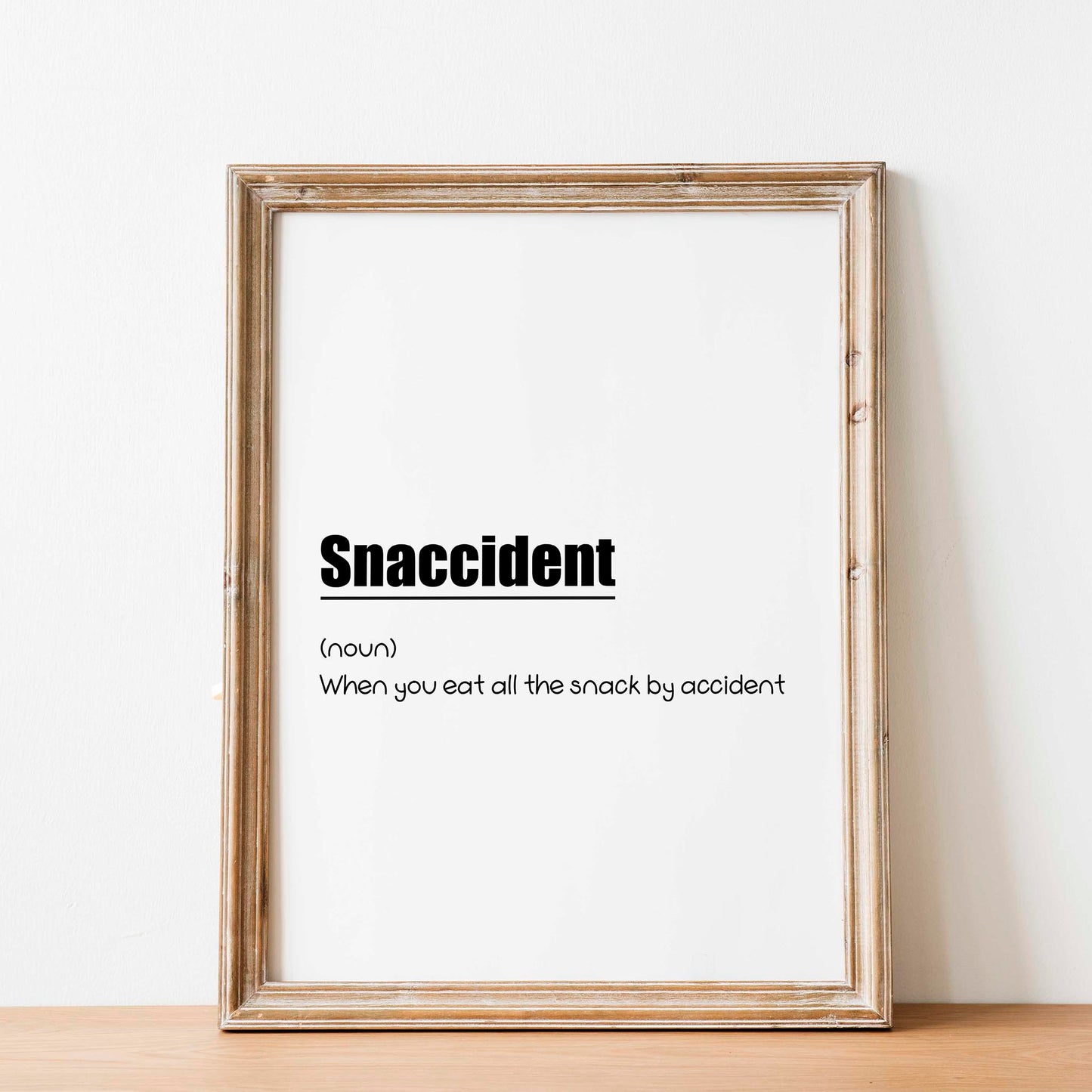 Funny printable wall art with the humorous definition 'Snaccident (noun): When you eat all the snack by accident' in playful black typography on a clean white background - perfect for kitchens, dining areas, or gift decor for food lovers