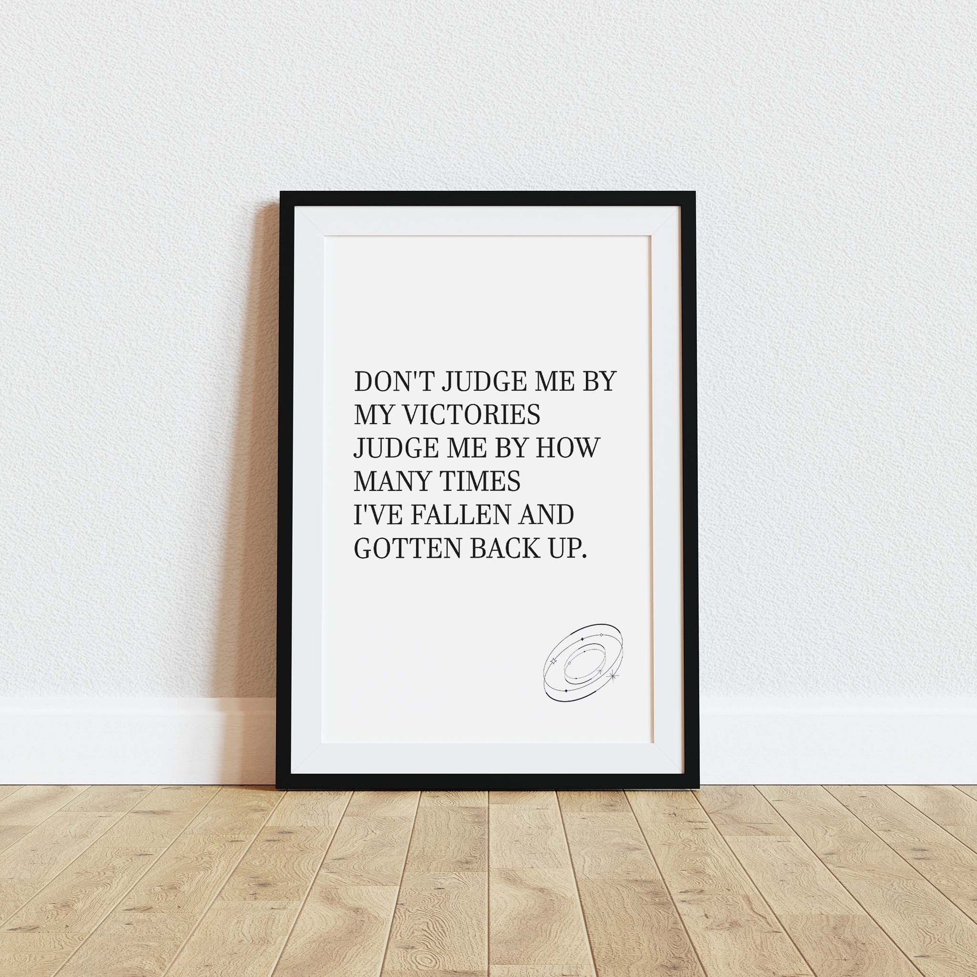 Inspirational printable wall art featuring the empowering quote 'Don't judge me by my victories, judge me by how many times I've fallen and gotten back up' in classic serif font, with a small sketched ring accent, perfect for resilience-themed or motivational spaces.