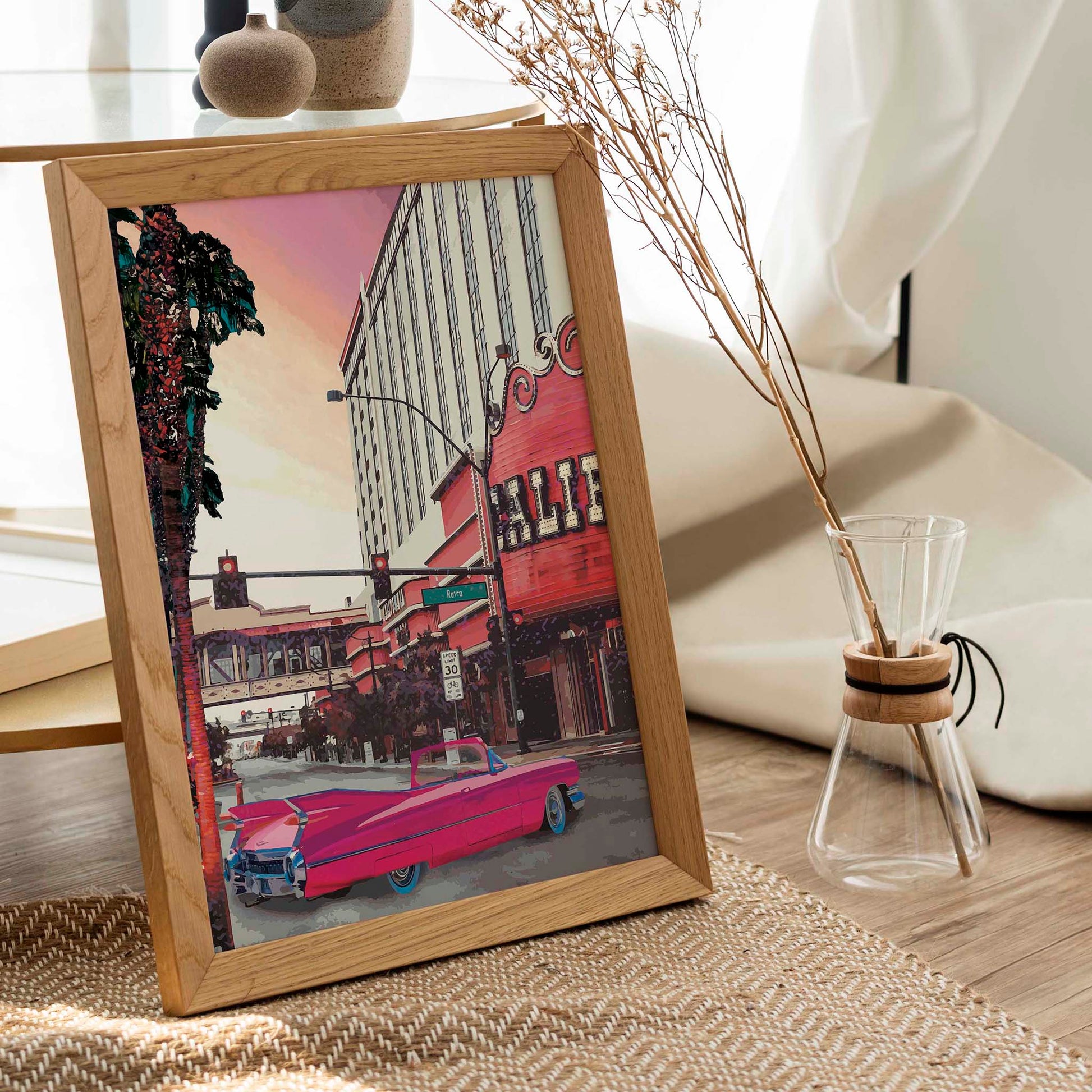 Printable wall art of a retro city street scene with a bright pink vintage convertible car, palm trees, and a classic theater marquee under a pastel sunset sky, perfect for nostalgic, urban-inspired home decor