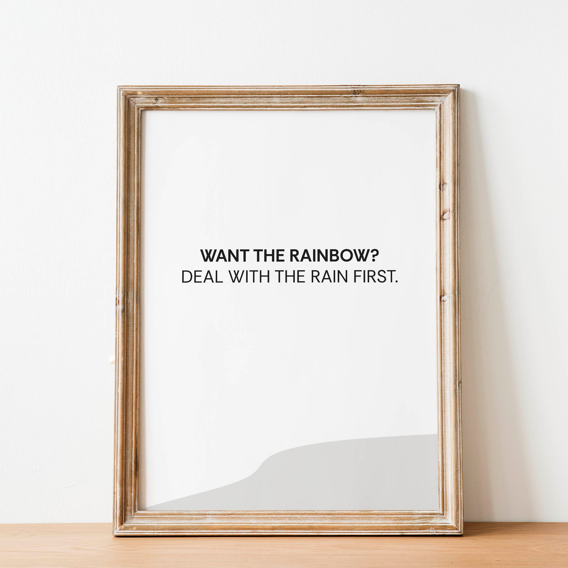 Minimalist motivational printable wall art featuring the quote 'Want the rainbow? Deal with the rain first.' in black text on a soft white background, perfect for inspiring resilience and patience in modern and calming spaces
