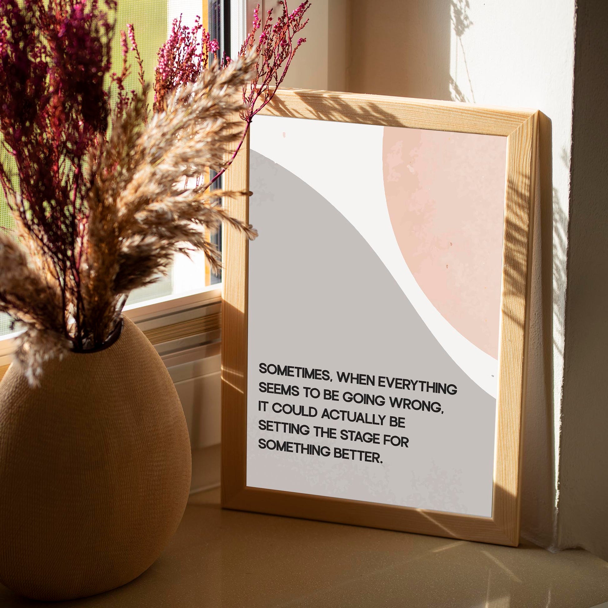 Modern motivational printable wall art featuring the quote 'Sometimes, when everything seems to be going wrong, it could actually be setting the stage for something better' in black text over abstract curved shapes in soft beige and peach tones, perfect for uplifting and calming interior spaces