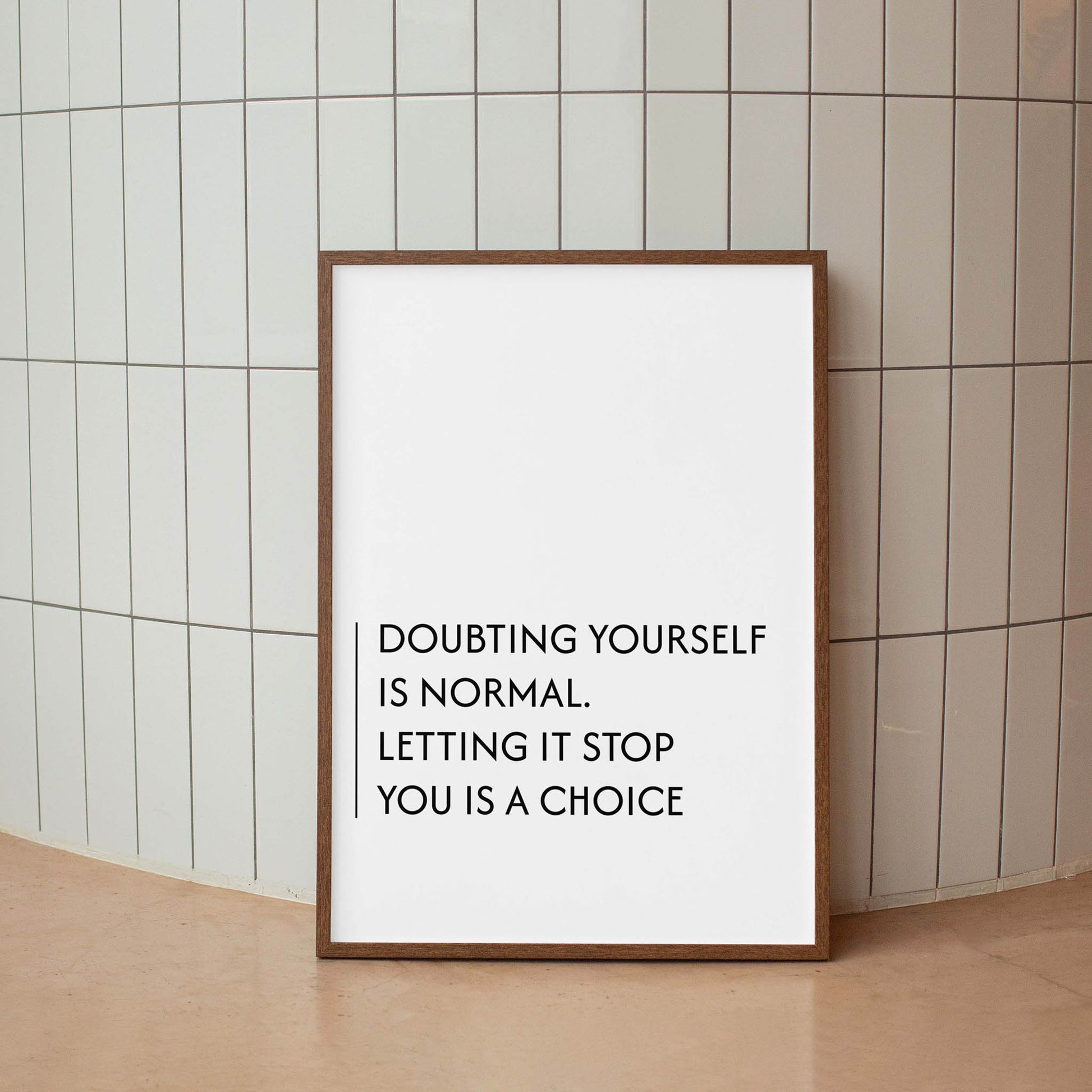 Minimalist motivational printable wall art with the quote 'Doubting yourself is normal. Letting it stop you is a choice' in clean black typography, set against a soft beige background with natural window light - ideal for office, bedroom, or personal growth spaces