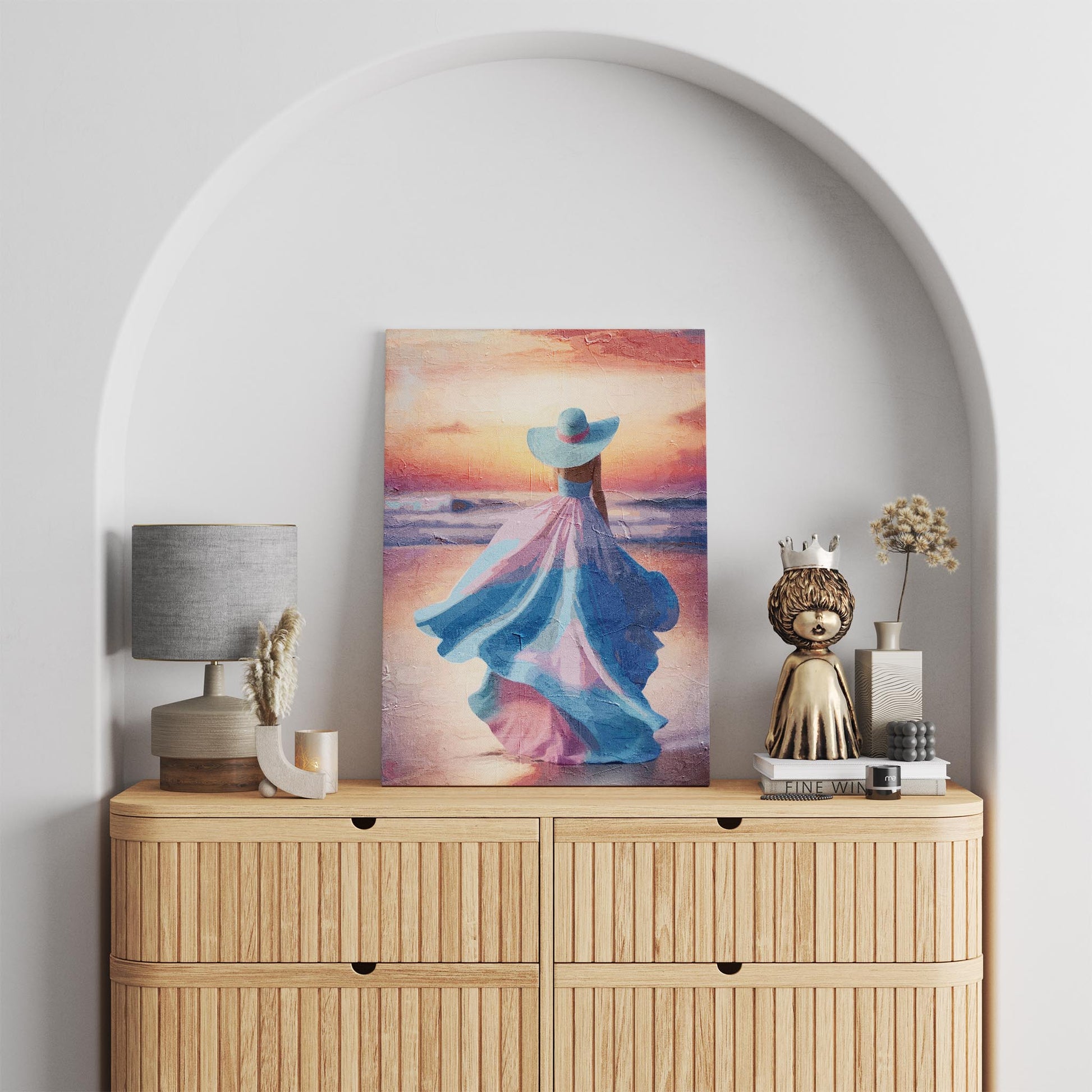 Elegant printable wall art of a woman in a flowing pastel pink and blue dress with a matching wide-brimmed hat, walking along the beach at sunset with soft waves and a glowing sky - perfect for feminine, coastal, or romantic-themed decor