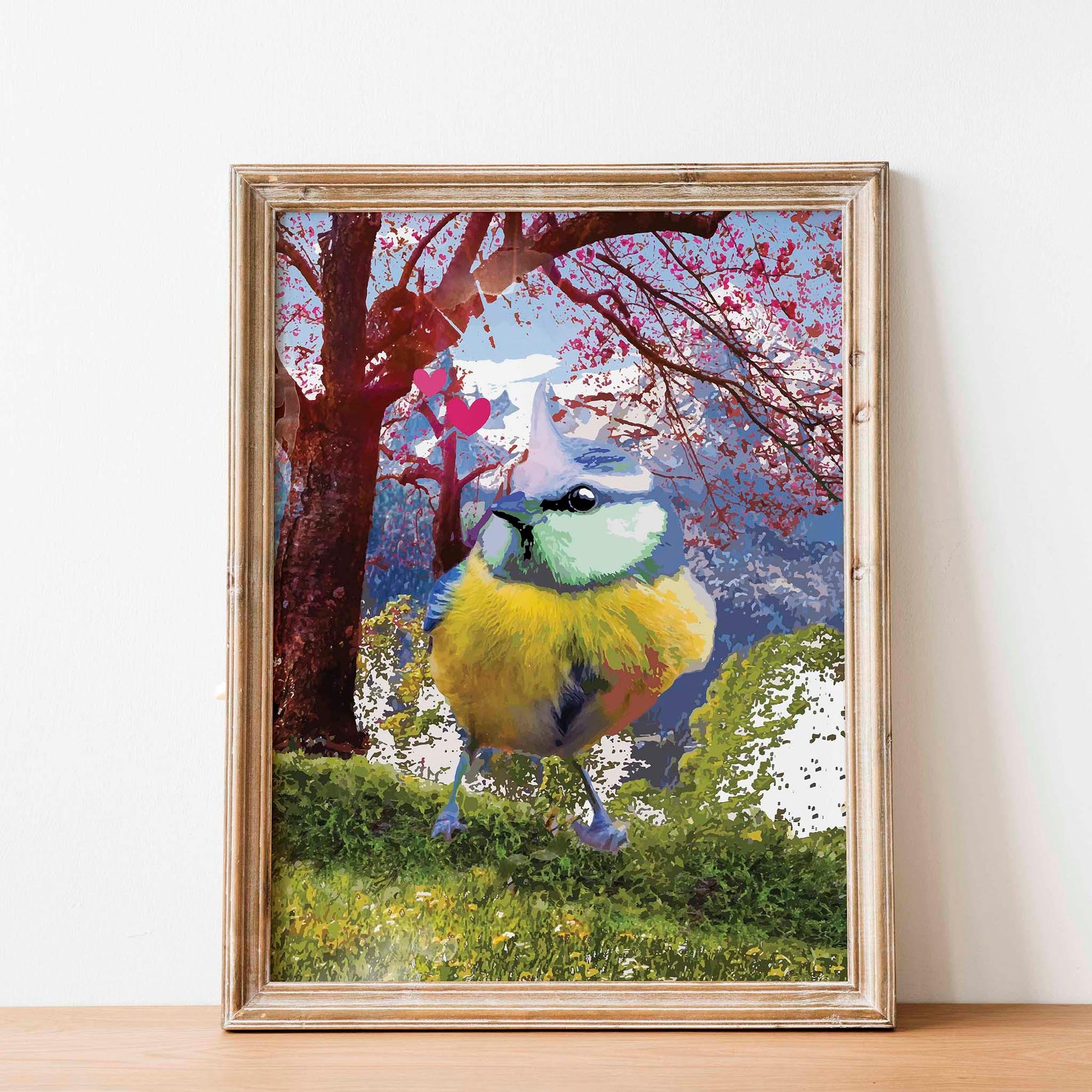 Printable wall art of a colorful songbird with vibrant blue, yellow, and green feathers standing on grass, with a dreamy cherry blossom tree, mountains, and pink hearts in the background, perfect for nature lovers and whimsical home decor