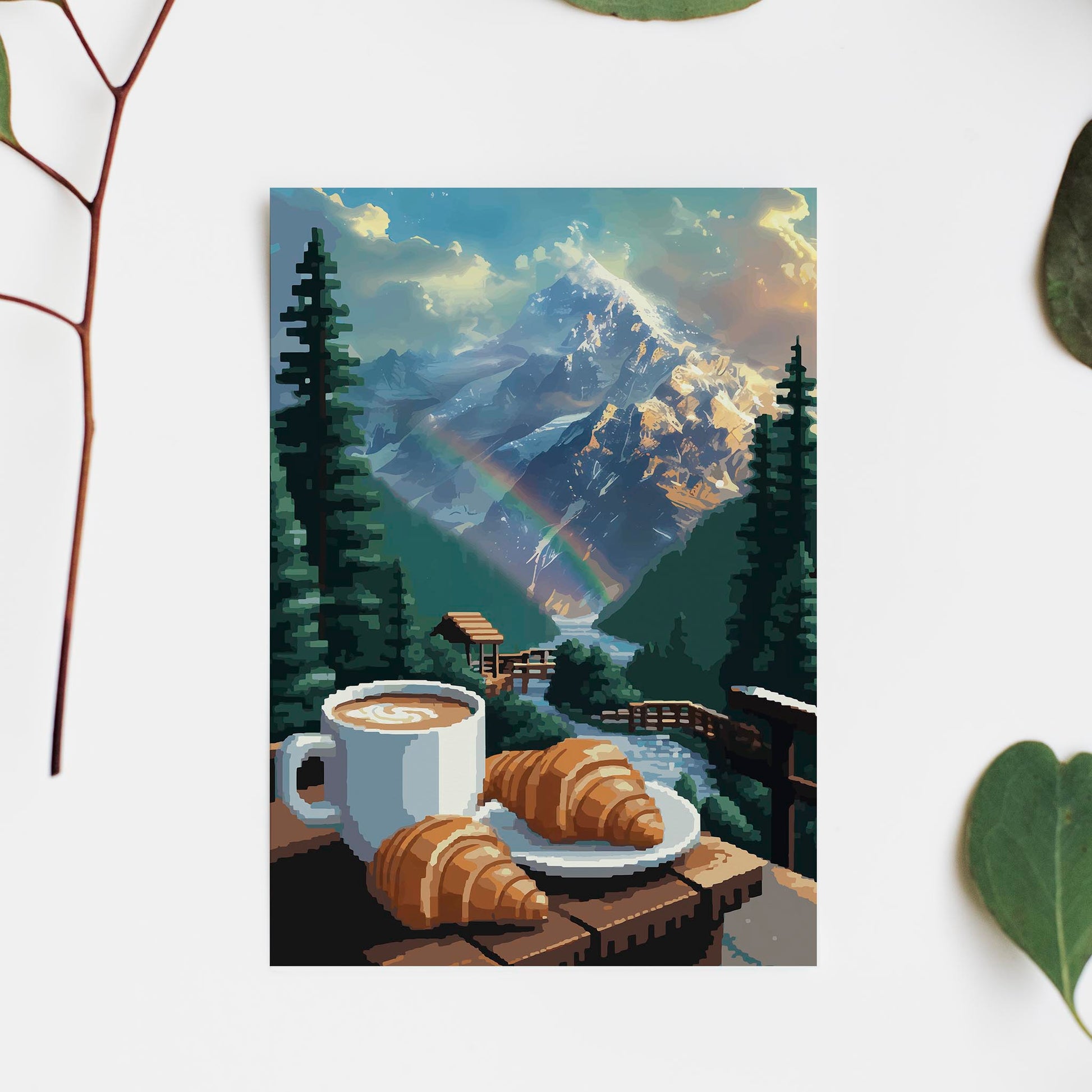 Cozy mountain-themed printable wall art featuring a cup of coffee and croissants on a wooden railing overlooking a flowing stream, lush pine trees, a rainbow, and majestic snow-covered peaks glowing in the morning light - perfect for cabin, breakfast nook, or nature lover decor