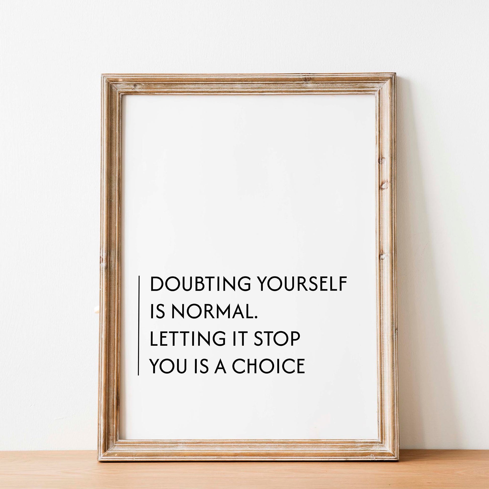 Minimalist motivational printable wall art with the quote 'Doubting yourself is normal. Letting it stop you is a choice' in clean black typography, set against a soft beige background with natural window light - ideal for office, bedroom, or personal growth spaces