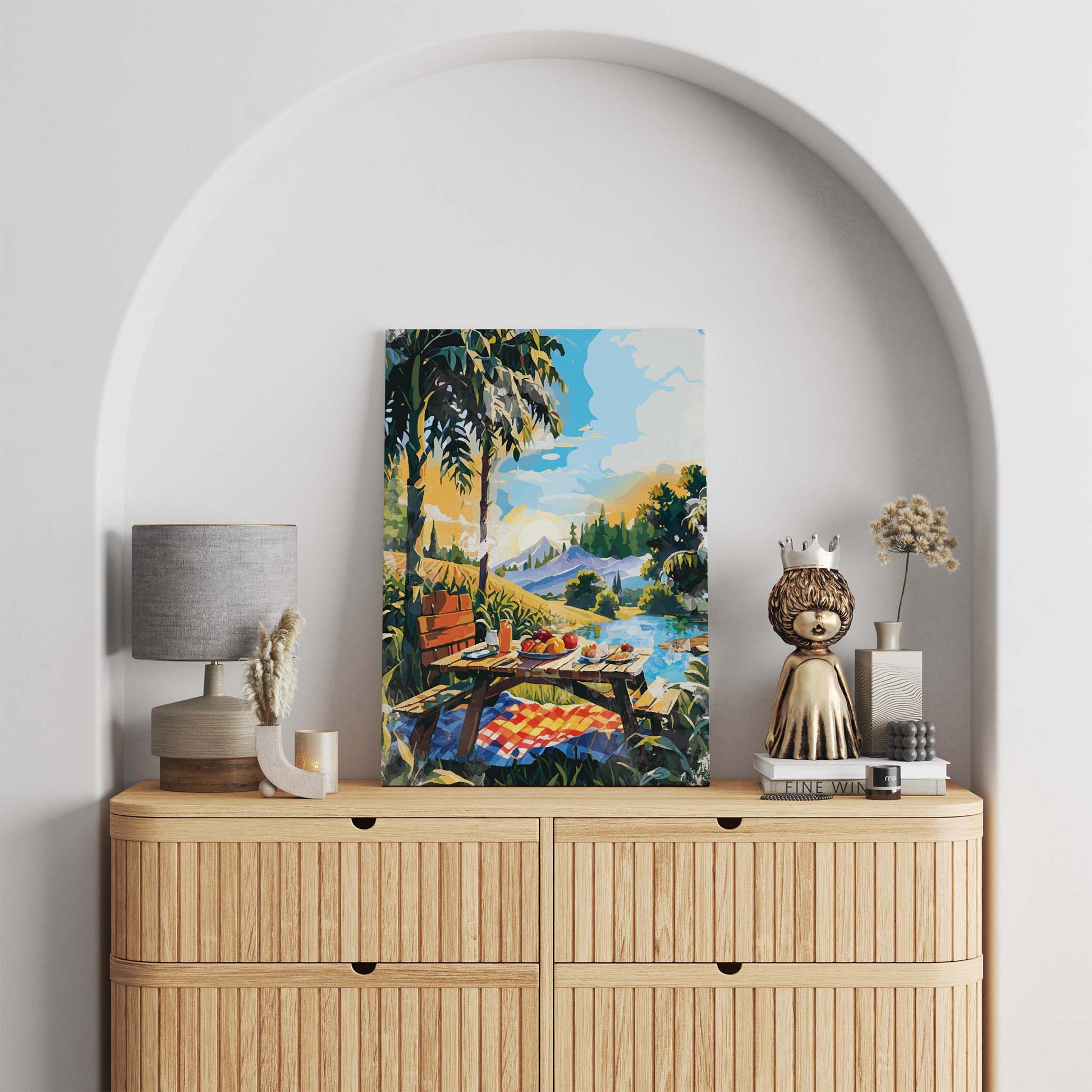 Vibrant picnic-themed printable wall art depicting a rustic wooden table set with fruit, juice, and pastries beside a lake, surrounded by palm trees, mountains, and a colorful sky - perfect for summer decor, kitchen walls, or outdoor-inspired spaces