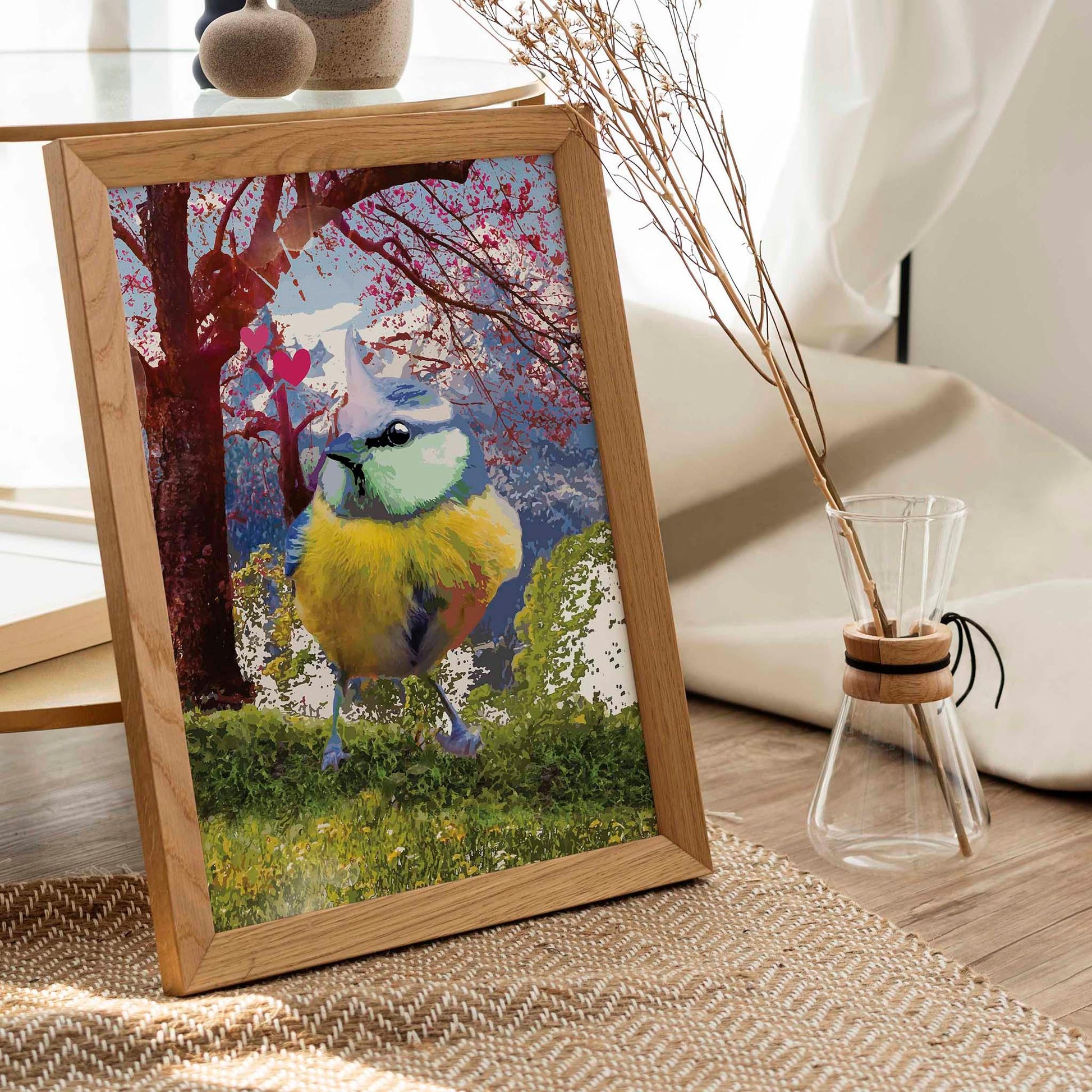 Printable wall art of a colorful songbird with vibrant blue, yellow, and green feathers standing on grass, with a dreamy cherry blossom tree, mountains, and pink hearts in the background, perfect for nature lovers and whimsical home decor