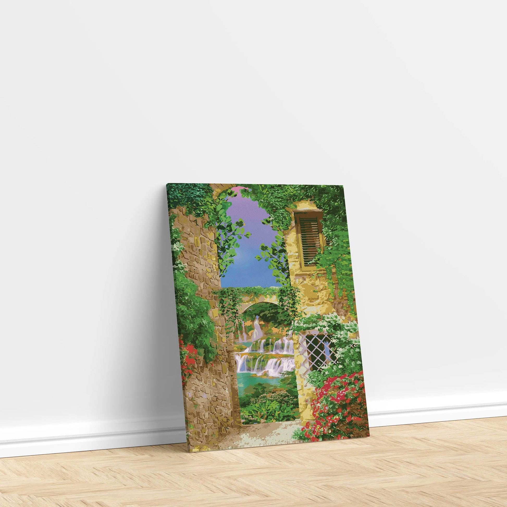 Charming printable wall art of a Mediterranean alleyway framed by ivy-covered stone buildings, with a view of cascading waterfalls and a stone bridge under a vibrant purple-blue sky, perfect for bringing a touch of European romance to your space