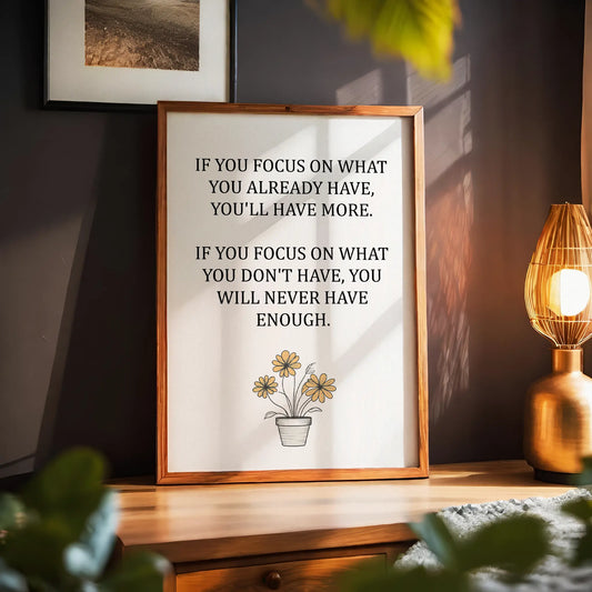 Inspirational printable wall art featuring the quote 'If you focus on what you already have, you'll have more. If you focus on what you don't have, you will never have enough,' with a simple daisy flower pot illustration and soft neutral background, ideal for gratitude-focused or minimalist decor