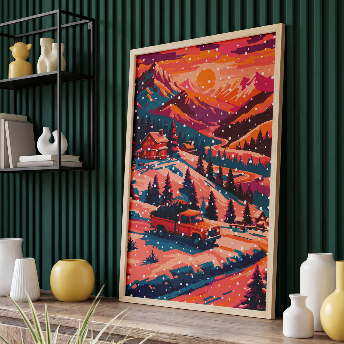 Bold illustrated Christmas landscape wall art with a red pickup truck carrying a Christmas tree through a snowy mountain valley, passing a glowing cabin and teal pine forest under an orange and magenta winter sky