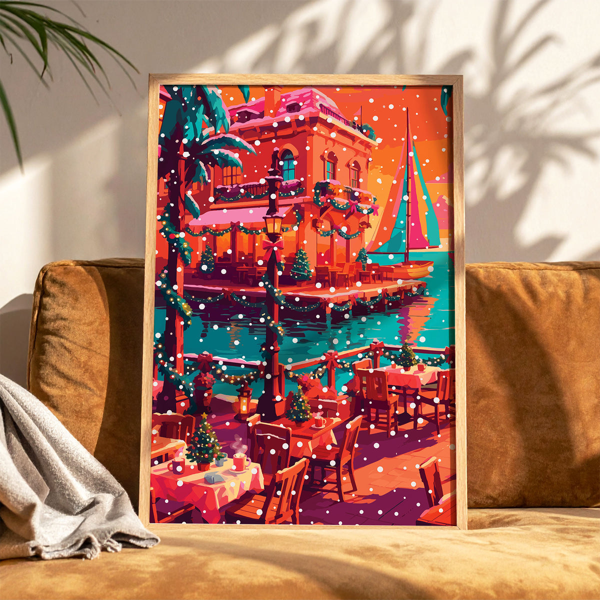 Bold illustrated Christmas waterfront wall art with a snow-dusted Mediterranean terrace café, teal sailboats on a turquoise harbour, garland-wrapped lampposts, mini Christmas trees on café tables, and a coral building decorated with wreaths under an orange winter sky