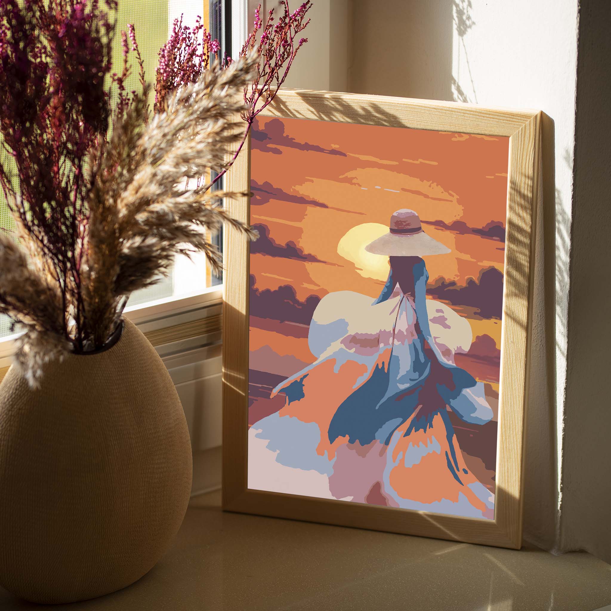 Romantic printable wall art featuring a woman in a flowing dress and wide-brimmed hat walking into a vibrant orange sunset, with abstract brushstrokes capturing movement, elegance, and a dreamy atmosphere