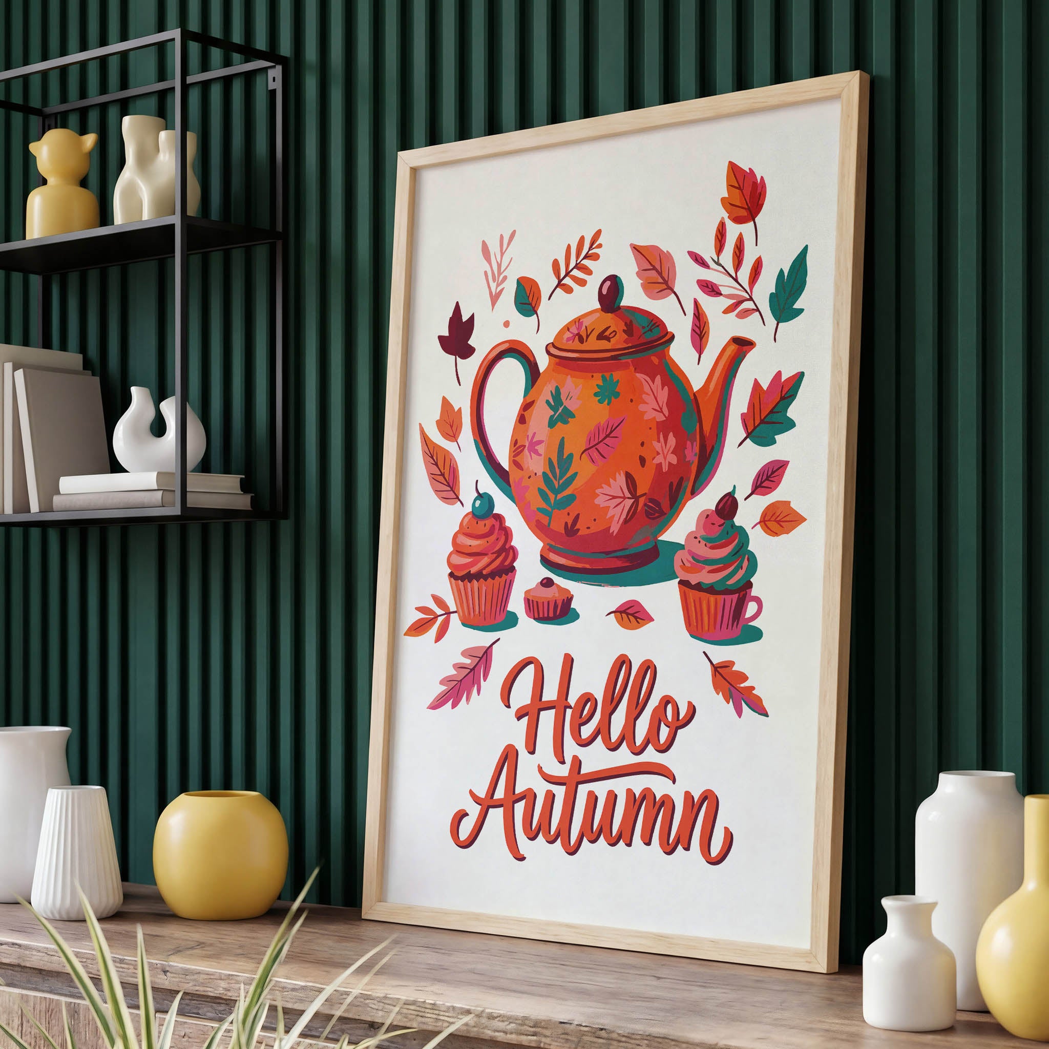 Painterly autumn kitchen poster - a large orange and teal patterned teapot surrounded by cupcakes with cherry toppers, fall leaves, and flowing "Hello Autumn" script lettering