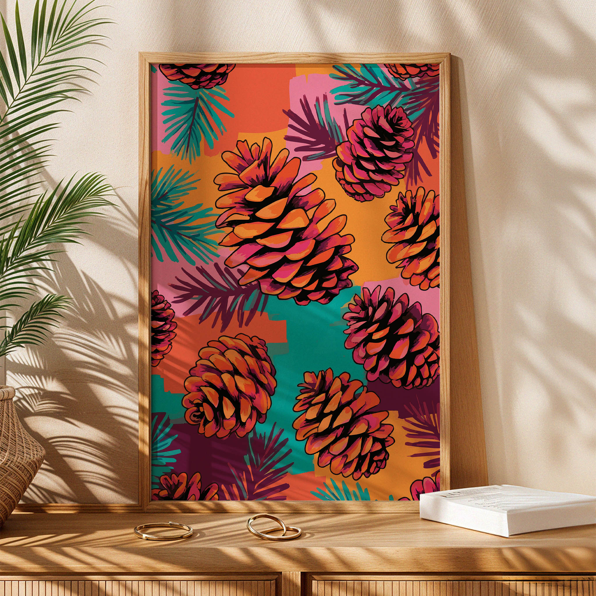 Close-up of a painterly pine cone print - orange and magenta cones with black outlines scattered across abstract colour block brushstrokes in warm and jewel tones