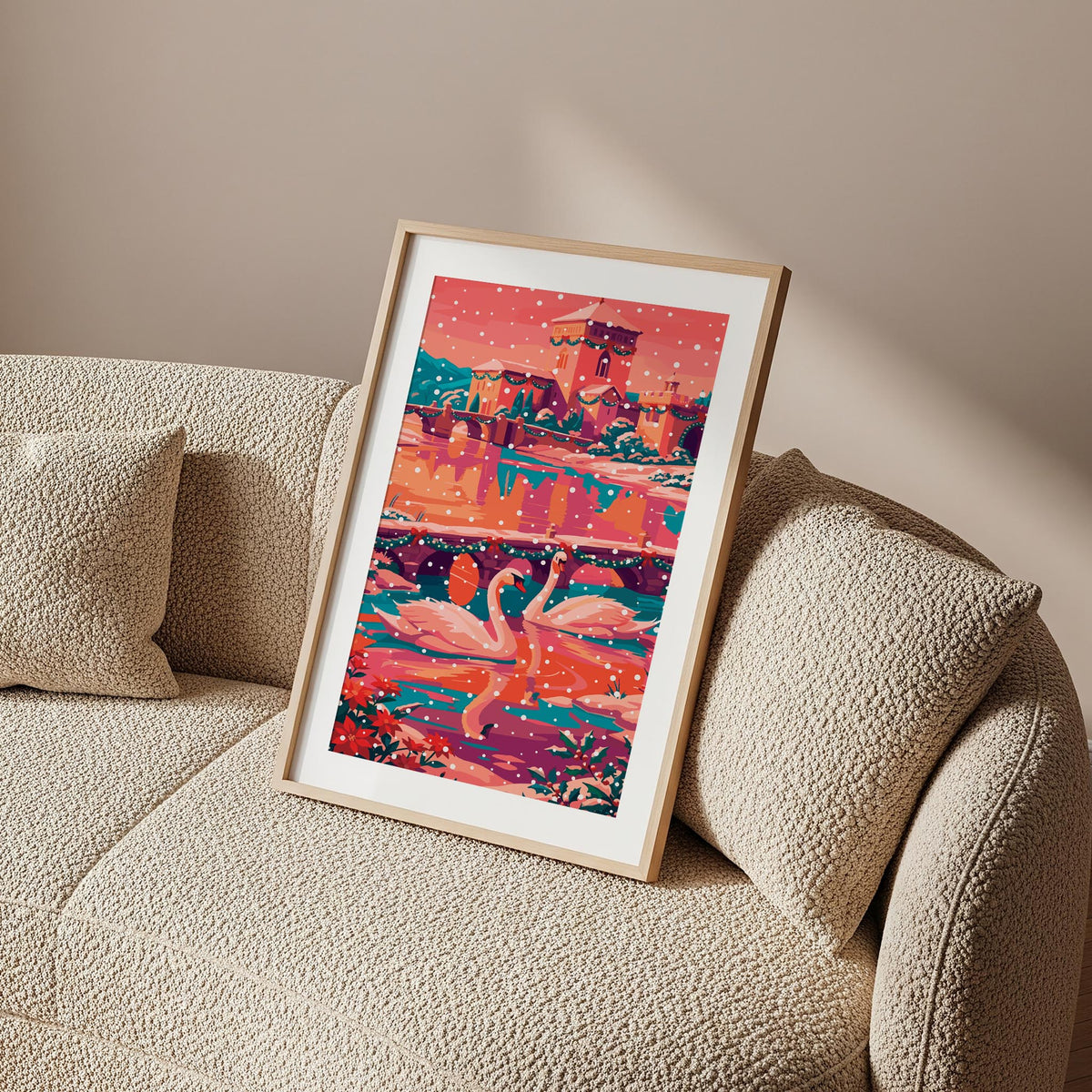 Illustrated print of two swans swimming on a river beneath garland-decorated stone bridges in a snowy European town. 