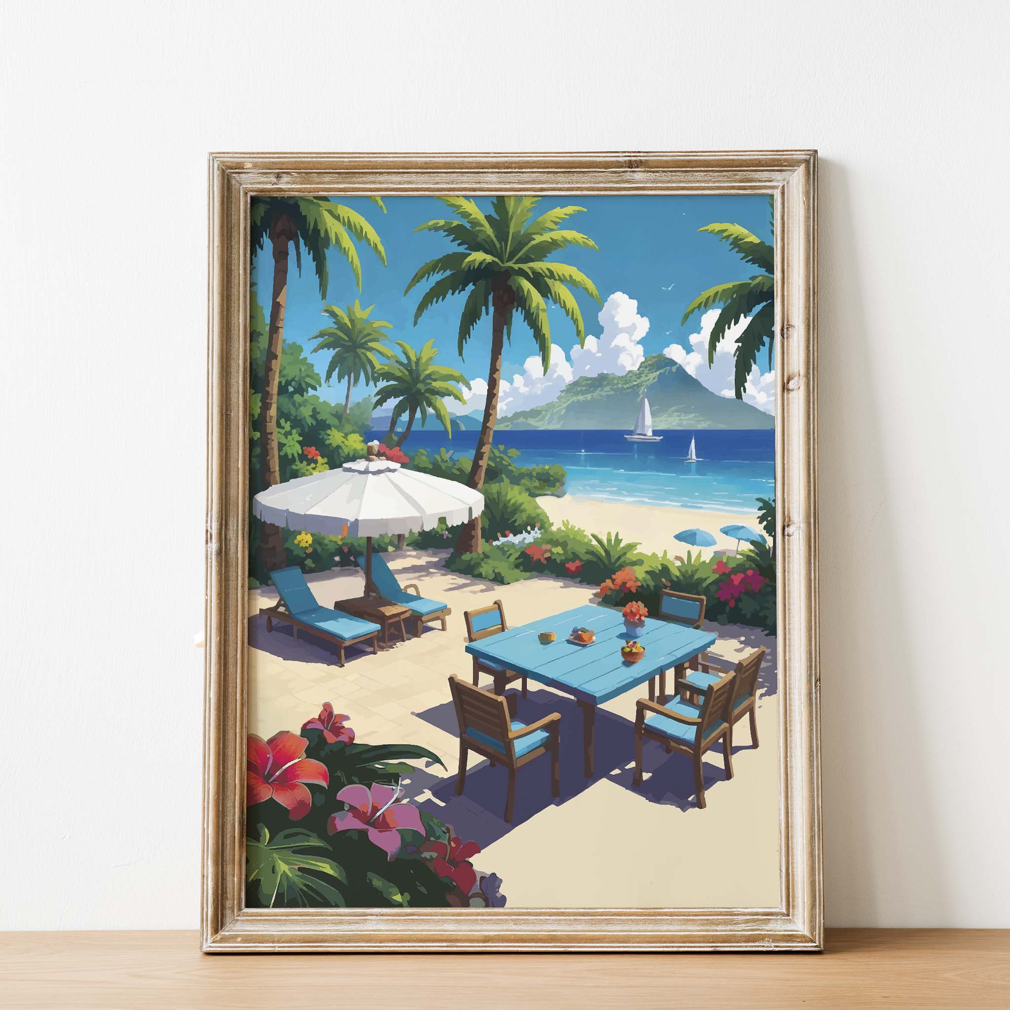 Tropical beachside printable wall art featuring a vibrant patio scene with a blue dining table, lounge chairs under a white umbrella, palm trees, colorful flowers, and sailboats on turquoise waters with a lush island in the background - perfect for summer, coastal, or vacation-themed decor