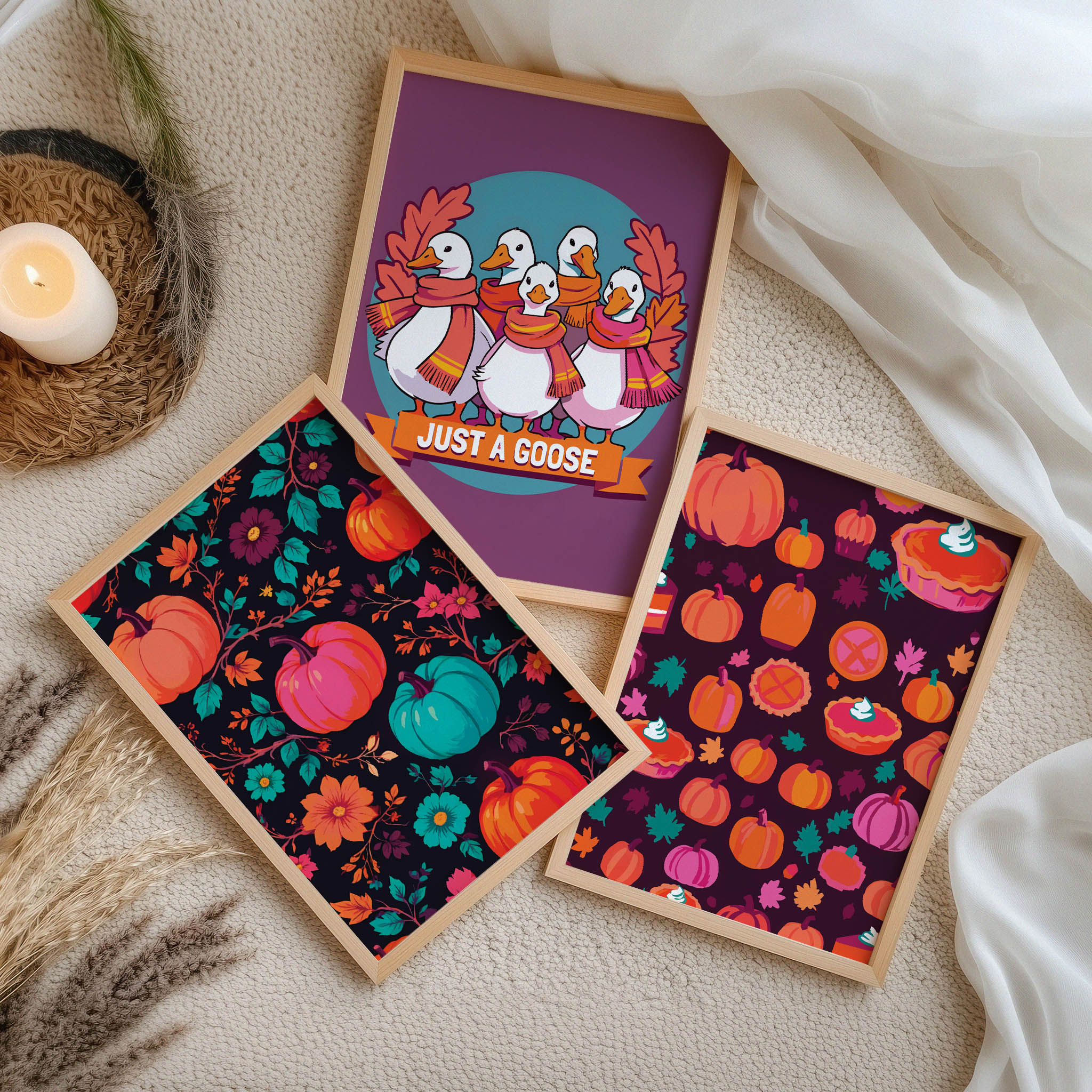 Sark-toned fall print bundle - three white-framed dopamine-style prints leaning on a natural oak ledge, featuring a black botanical pumpkin print, a humorous goose poster, and a burgundy harvest pattern