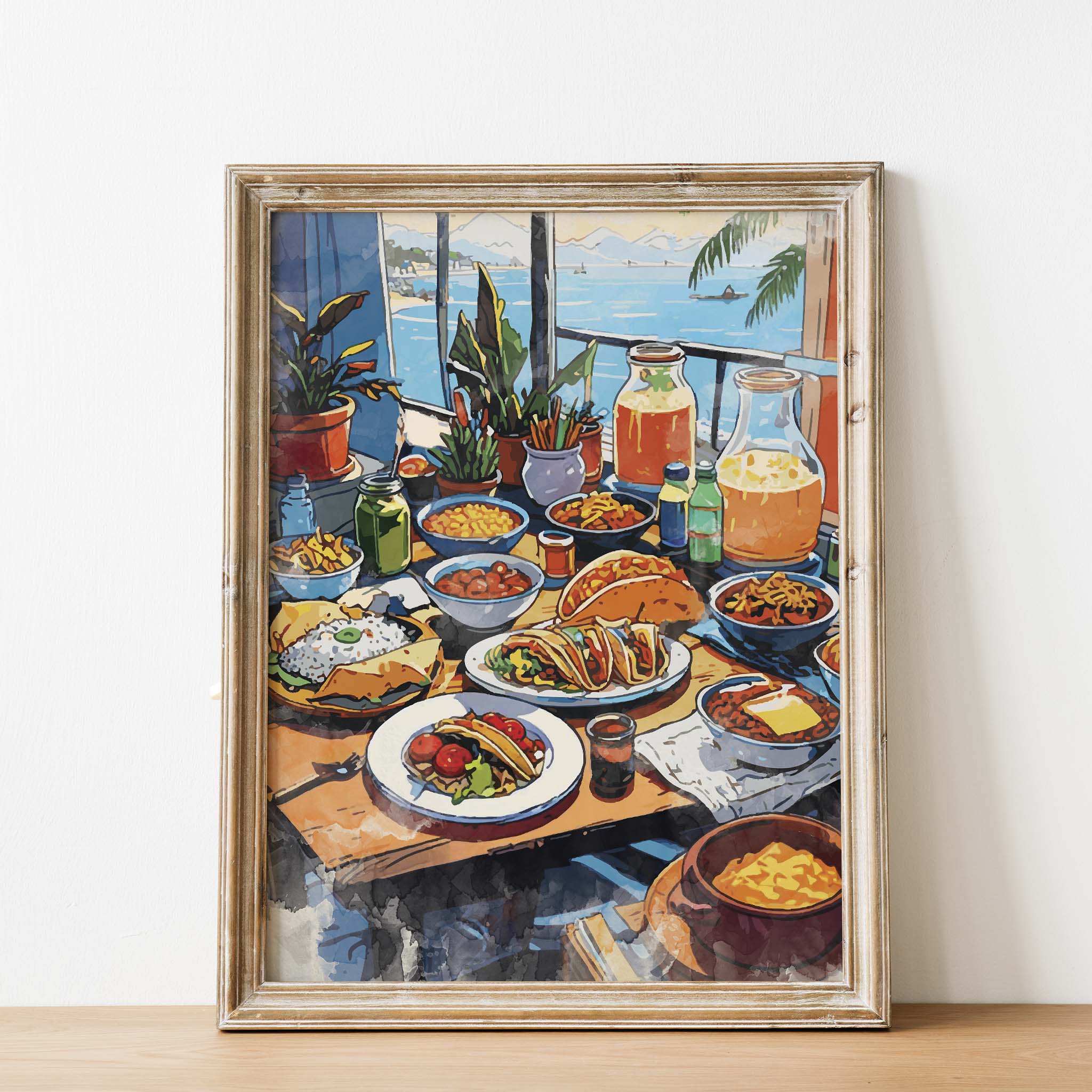 Colorful printable wall art of a festive Mexican dining table filled with tacos, rice, pasta, fresh vegetables, drinks, and juices, set against a scenic seaside view with potted plants and sailboats in the distance.