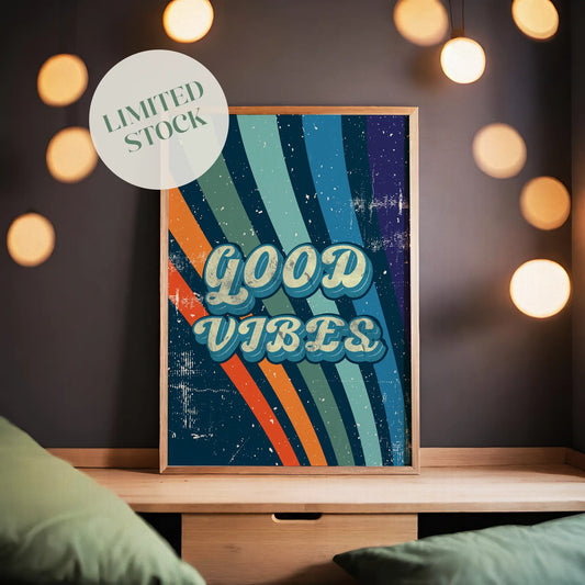 Printable wall art with a retro ‘Good Vibes’ typography in bold vintage-style letters, over a colorful striped background with a distressed, textured finish, perfect for positive, nostalgic home decor