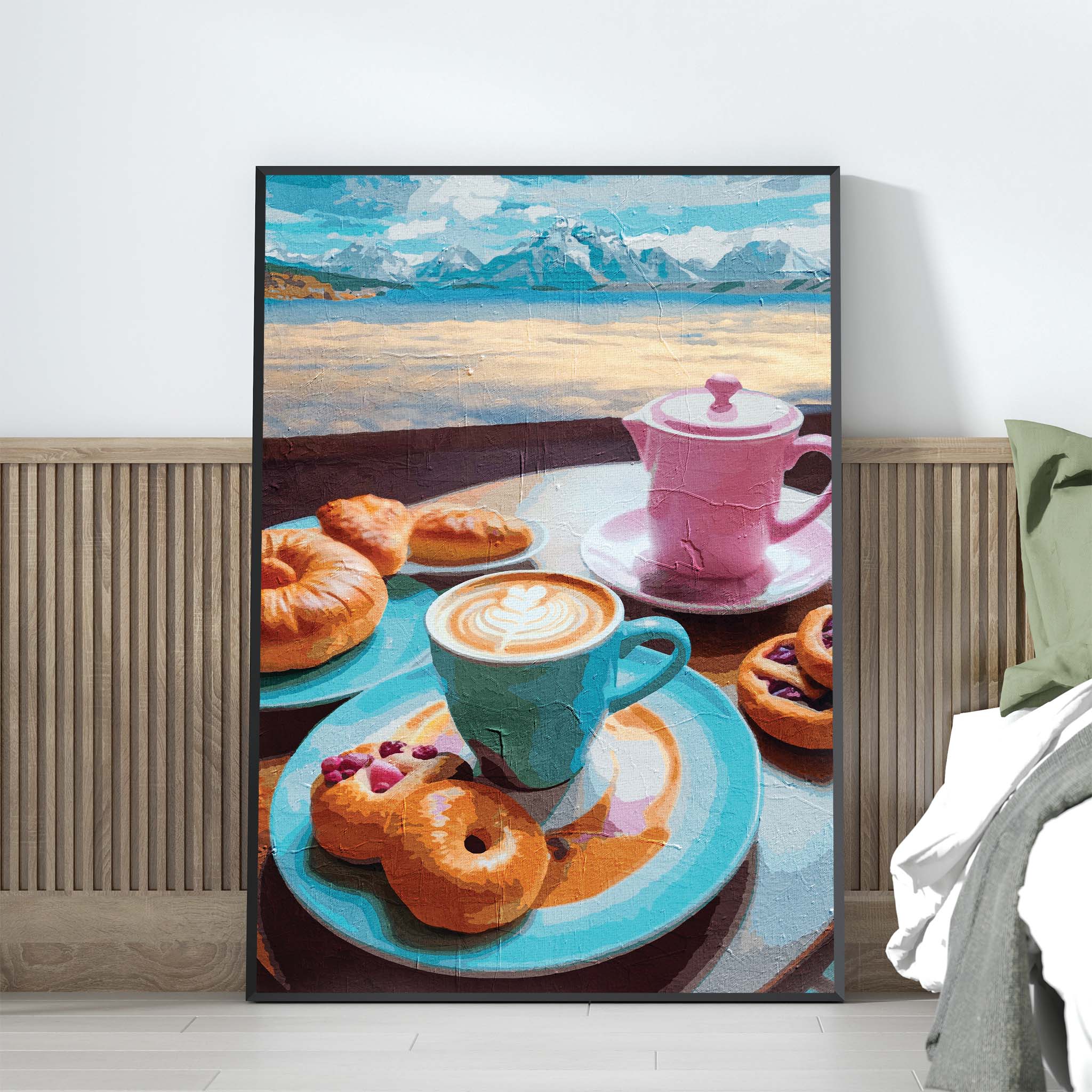 Printable wall art of a charming breakfast scene with a blue coffee cup, pink teapot, assorted pastries, and donuts on colorful plates, set against a scenic backdrop of mountains and water, perfect for kitchen or café-inspired decor.