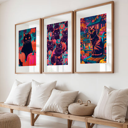 Three white-framed dopamine-style prints on a natural oak ledge showing a single black cat portrait, a multi-cat pumpkin pattern, and a full Halloween yard scene with a glowing haunted house