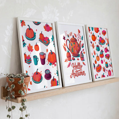 Room mockup of a fall print bundle - three white-framed illustrated prints displayed on a natural wood ledge with a trailing green plant, showing pumpkin, book, and teapot autumn designs