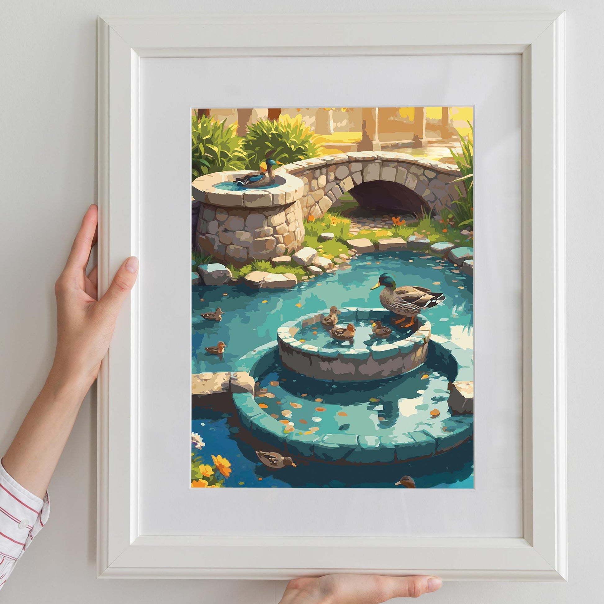 Charming illustrated garden scene featuring ducks and ducklings swimming in a turquoise pond with a tiered stone fountain and a small stone bridge in the background. Surrounded by lush greenery and warm sunlight, the artwork creates a peaceful, storybook countryside atmosphere. Printable Wall Art. Digital Download.