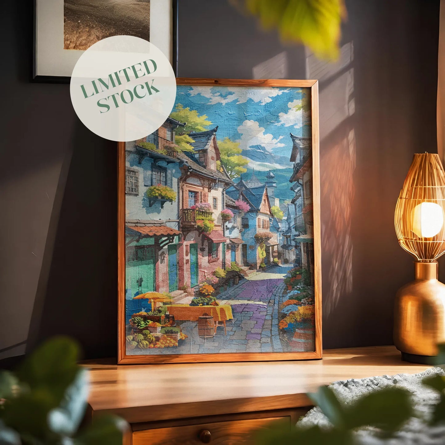 Charming printable wall art of a colorful European-style village street, lined with flower-filled balconies, cobblestone paths, and a market table with fruits and flowers under a sunny blue sky, perfect for travel-inspired, vintage, or Mediterranean-themed decor