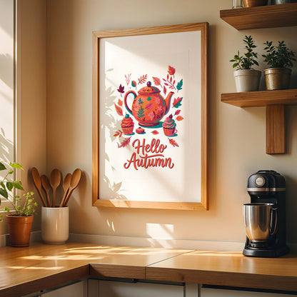 Hello Autumn" illustrated kitchen print on a white background featuring a painted orange teapot with teal leaf details, frosted cupcakes, and scattered fall foliage in orange and pink