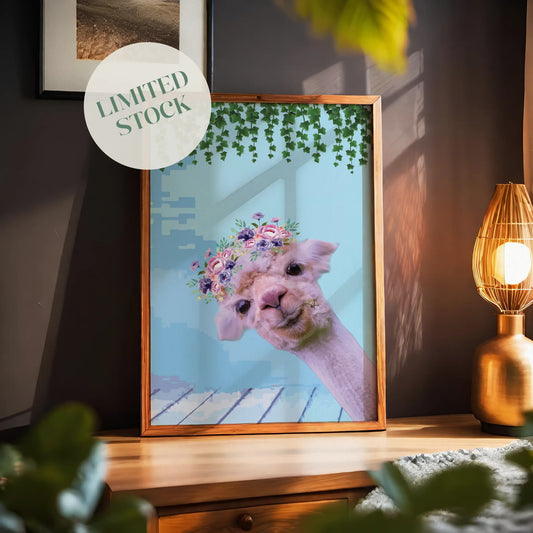 Whimsical printable wall art featuring a cute alpaca with a floral crown, set against a pastel blue background with hanging greenery, perfect for kids’ rooms, nurseries, or boho animal decor lovers.