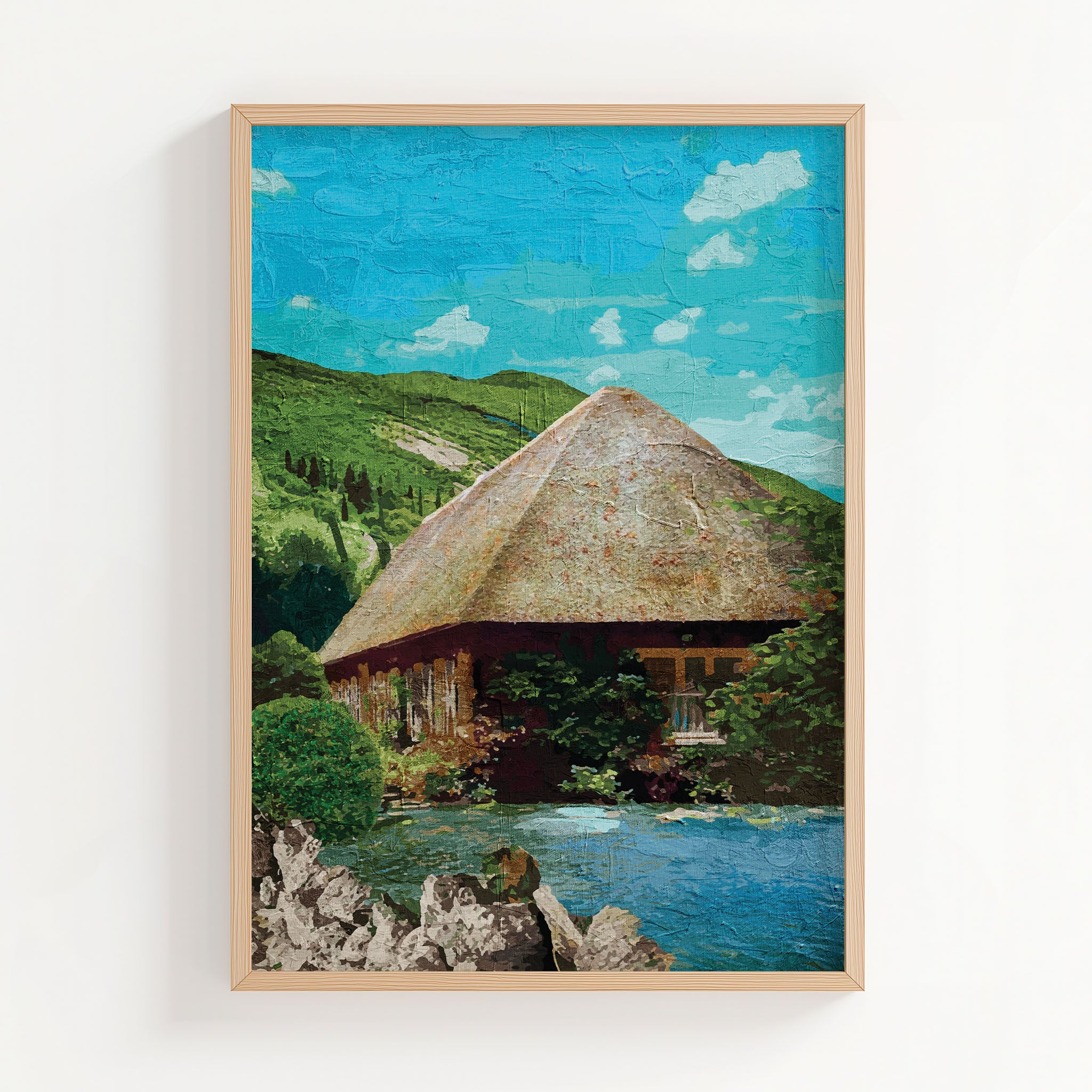 Rustic cottage wall art featuring a charming thatched-roof house surrounded by lush greenery and nestled beside a peaceful pond, with rolling green hills and a bright blue sky in the background