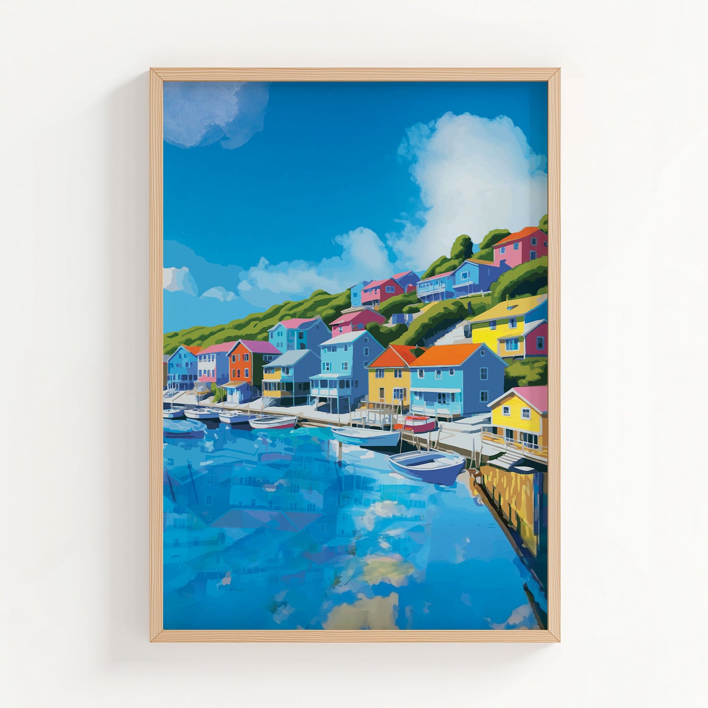 Charming harbor town wall art featuring vibrant seaside houses in bold colors lining a hillside above a marina filled with boats, under a bright blue sky with fluffy clouds reflected in the water