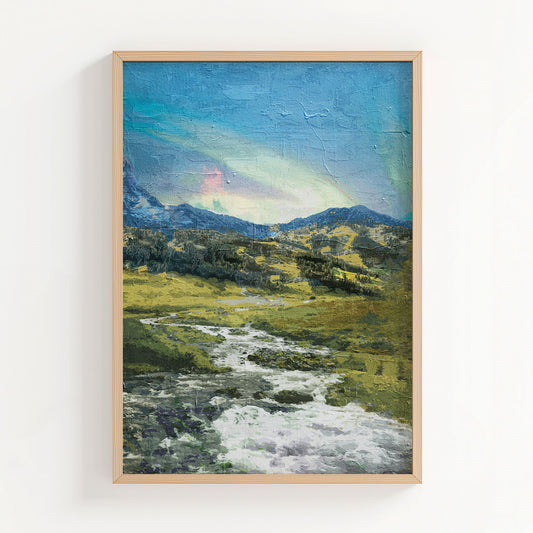 Rustic mountain valley wall art featuring a flowing stream winding through grassy hills and rocky terrain, with forested slopes and a soft, colorful sky above the distant peaks