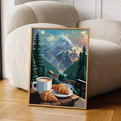 Cozy mountain-themed printable wall art featuring a cup of coffee and croissants on a wooden railing overlooking a flowing stream, lush pine trees, a rainbow, and majestic snow-covered peaks glowing in the morning light - perfect for cabin, breakfast nook, or nature lover decor