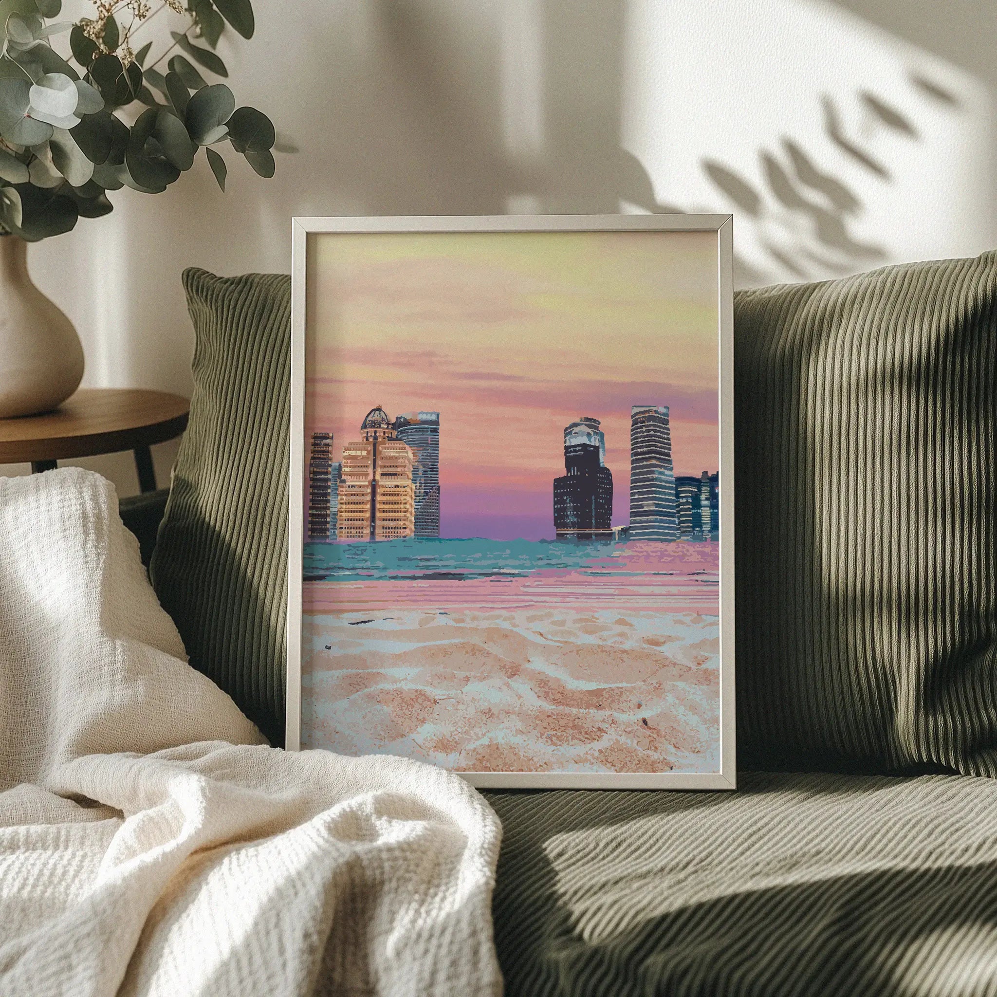 Modern cityscape wall art featuring futuristic skyscrapers along a beach shoreline, with soft sand in the foreground and a vibrant pastel sunset sky blending shades of pink, orange, and purple