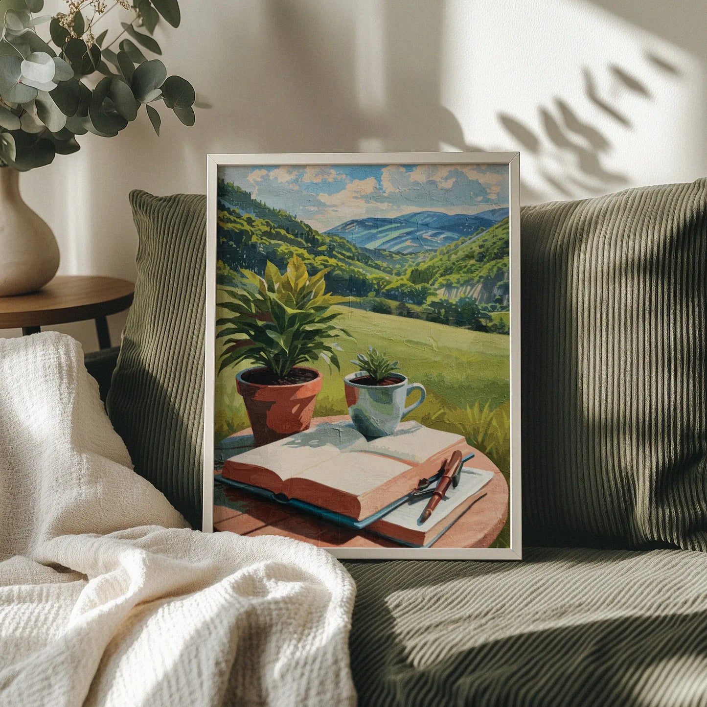 Peaceful printable wall art depicting an open book, pen, coffee cup, and potted plants on a table overlooking lush green hills and distant mountains under a sunny sky - perfect for writers, book lovers, or cozy nature-inspired decor