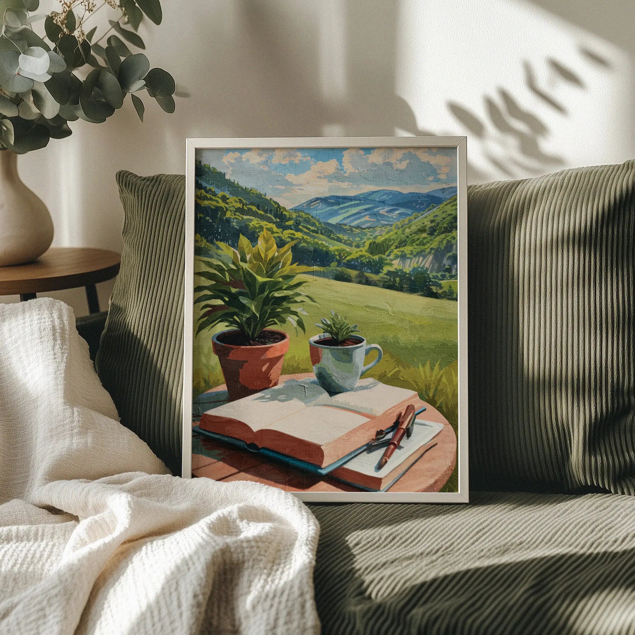 Peaceful printable wall art depicting an open book, pen, coffee cup, and potted plants on a table overlooking lush green hills and distant mountains under a sunny sky - perfect for writers, book lovers, or cozy nature-inspired decor