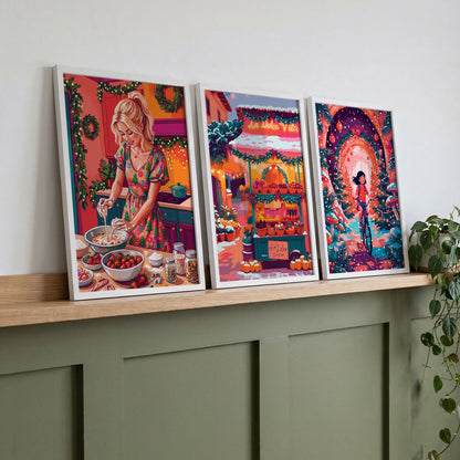 Set of three colorful holiday wall art prints displayed on a wooden shelf above a green console