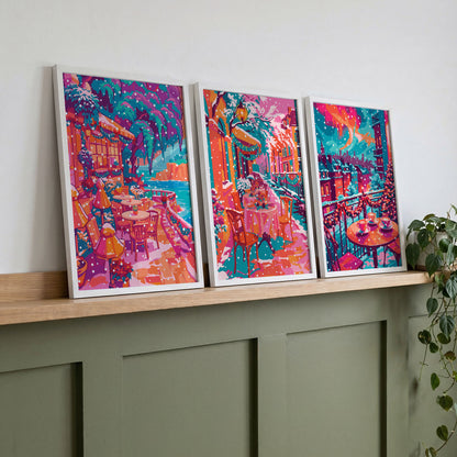 Set of three pink and teal winter café scenes displayed on a wooden shelf above a green console