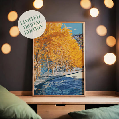 Autumn city park wall art featuring a row of golden-yellow trees along a riverbank, with reflections in the water and a hillside town in the distance under a clear blue sky