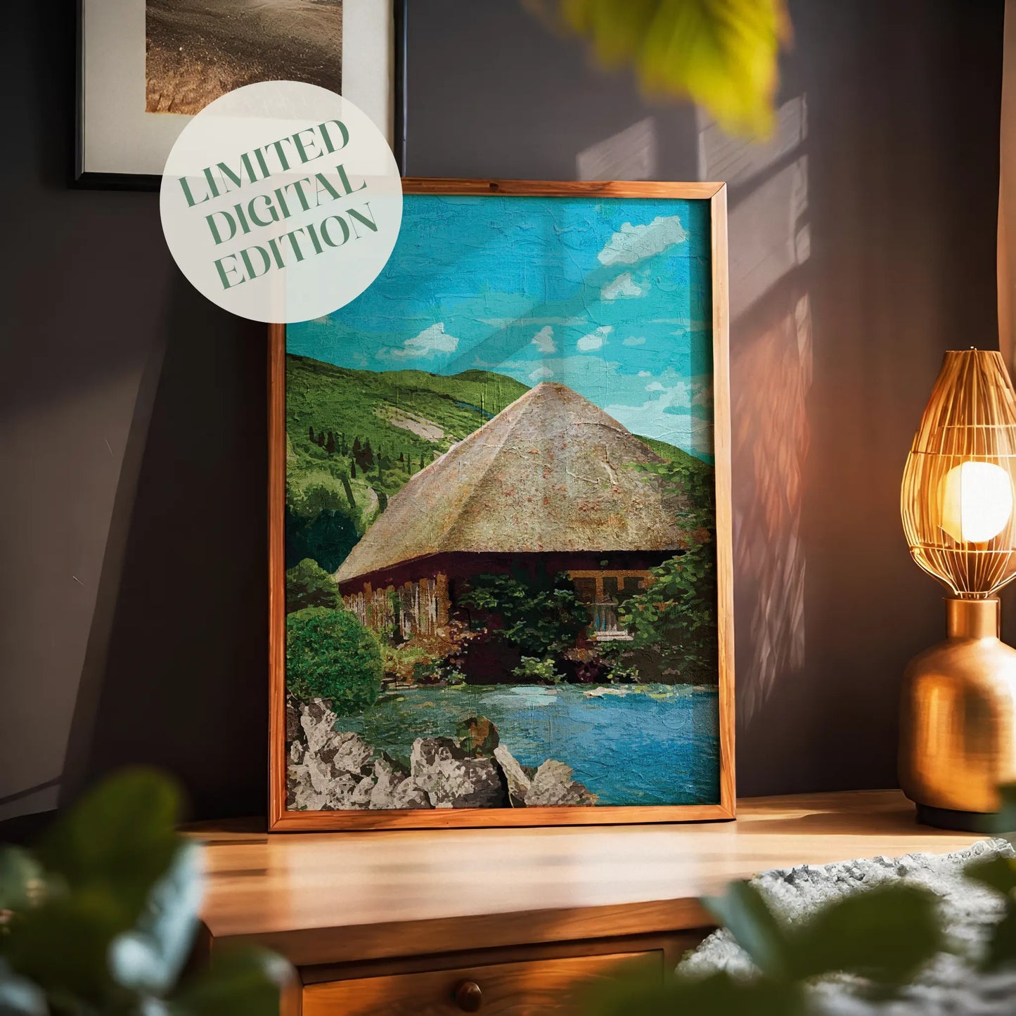 Rustic cottage wall art featuring a charming thatched-roof house surrounded by lush greenery and nestled beside a peaceful pond, with rolling green hills and a bright blue sky in the background